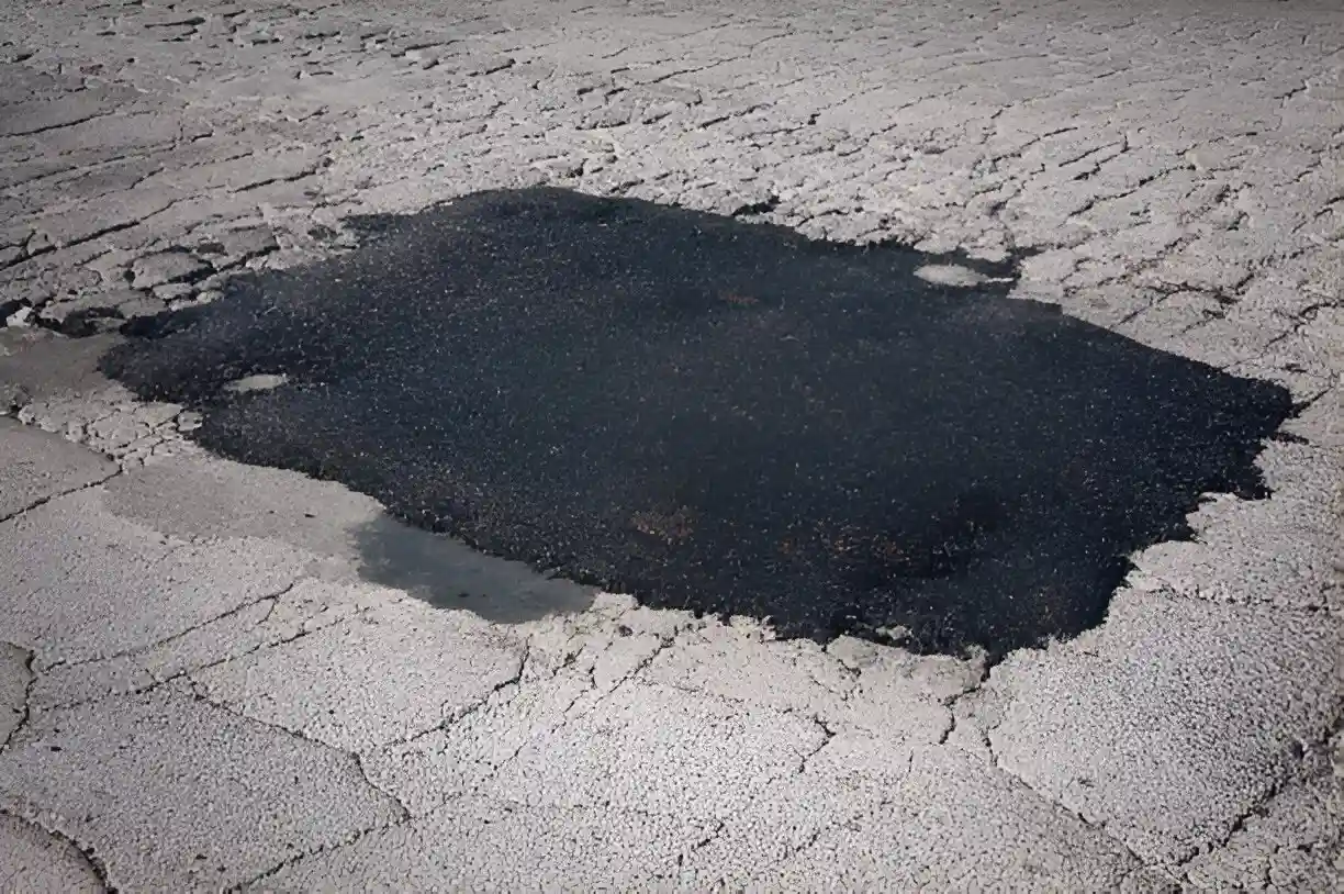 An asphalt patch where a pothole used to be.